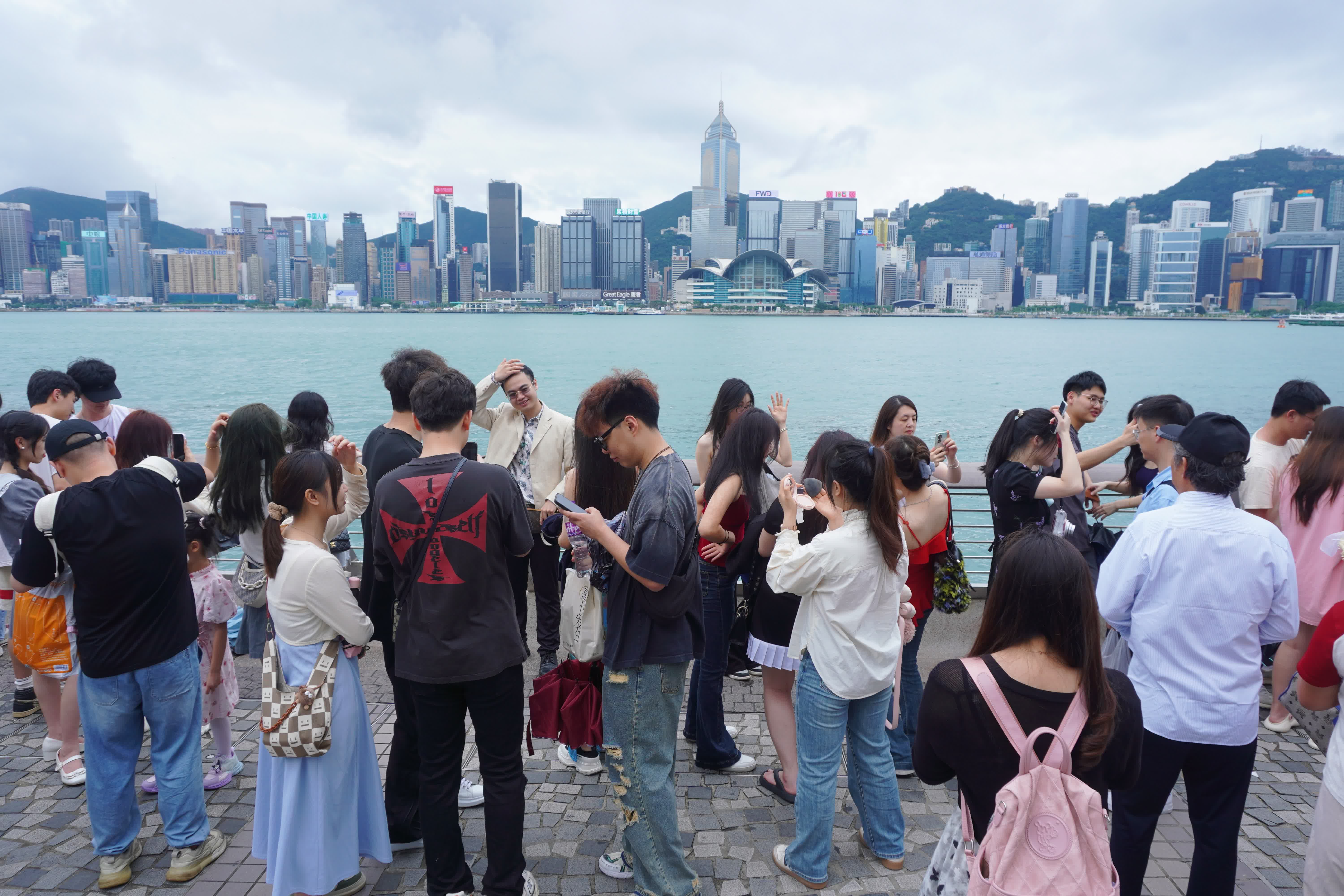 圖為遊客在尖沙咀打卡拍照。（香港中通社）