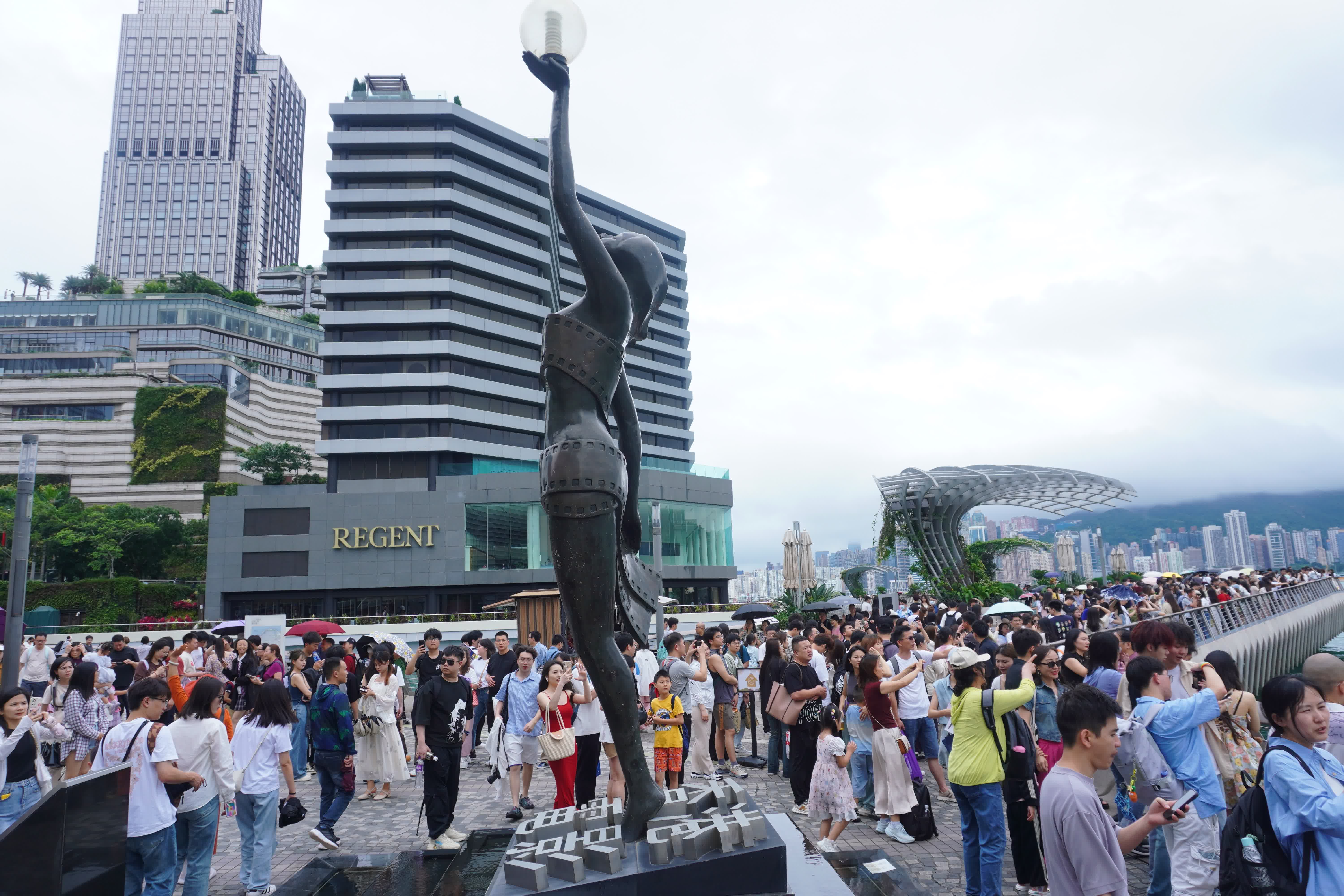 圖為遊客在尖沙咀打卡拍照。（香港中通社）