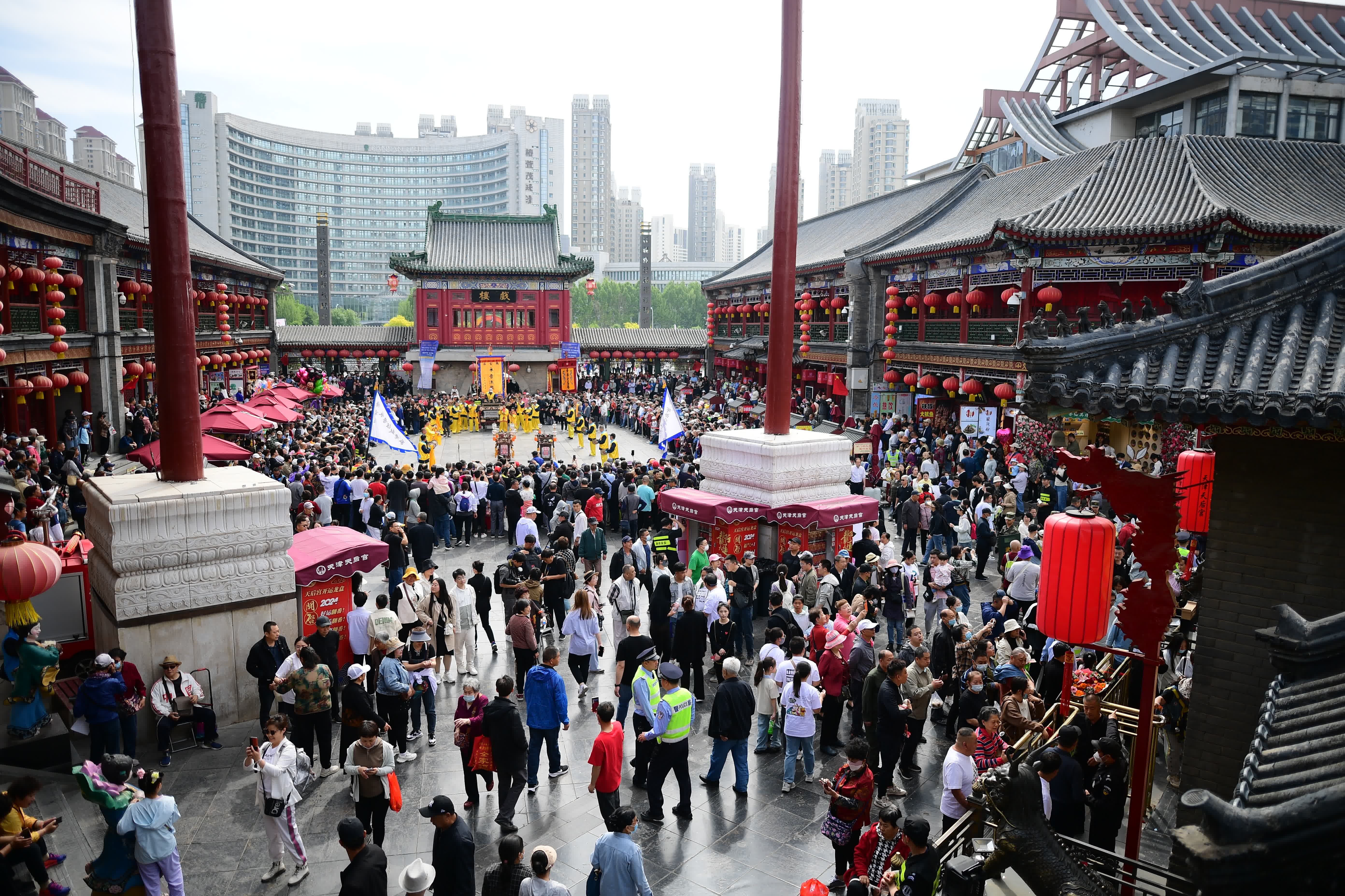 圖為5月1日，市民(mín)和遊客在天津古文(wén)化街(jiē)觀看民(mín)俗展演。（中新(xīn)社）